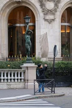 Tourist taking a selfie in front of a historic statue near a luxurious buil.. Stock Photos
