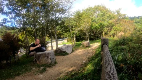 Tourist is taking selfie while doing yoga pose on the bench. Stock Footage 129309148