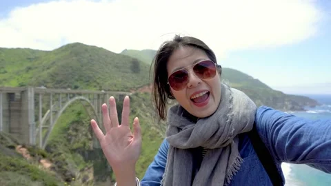 Tourist talking on video call share Big Sur view Video stock 130834584