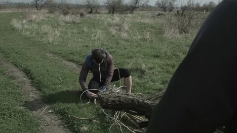 The tourist throws large dry branches on his shoulder Stock Footage