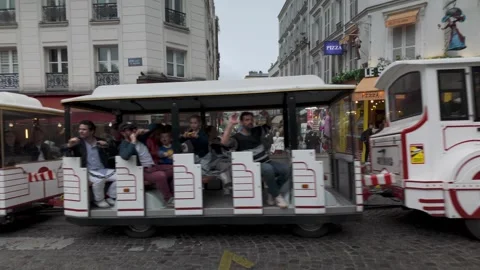 Tourist train rides through lively Paris streets as visitors enjoy the city’s 動画素材 314302926