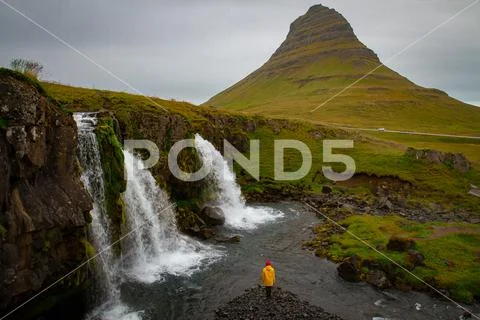 Tourist under the waterfall in Iceland, Adventure photo, edit sp Stock Photos