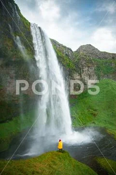Tourist under the waterfall in Iceland, Adventure photo, edit sp Stock Photos