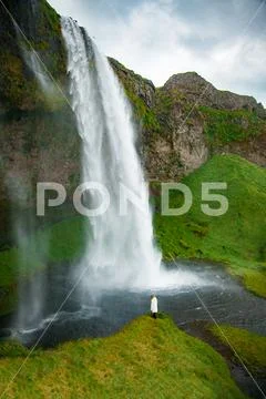 Tourist under the waterfall in Iceland, Adventure photo, edit sp Stock Photos