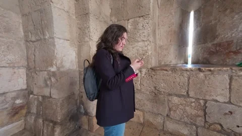 Tourist using smartphone in ancient Jerusalem tower window. Stock Footage 325197225