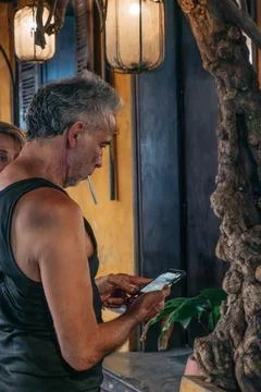 Tourist using smartphone beside lanterns in Hoi An Foto stock