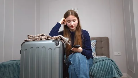 Tourist using smartphone while waiting in hotel room Stock Footage 309775353
