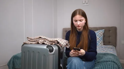 Tourist using smartphone while waiting in hotel room Vidéo 309775535