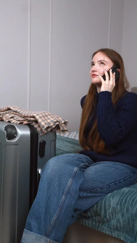 Tourist using smartphone while waiting in hotel room Stock Footage 309775647