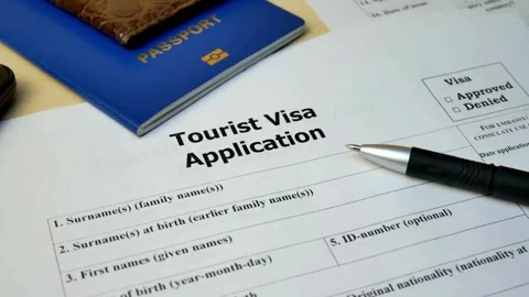 Tourist visa application form with blue passport and smartphone close up Stock Footage 332725199