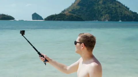 Tourist vlogging on the beach Stock-Footage 106197428