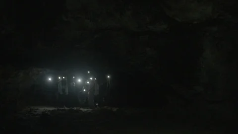 Tourist walking in the dark cave Stock Footage 87700540