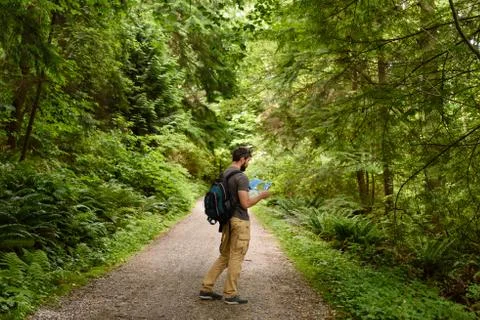 Tourist on a walking path looking at map in public park Stock-Fotos