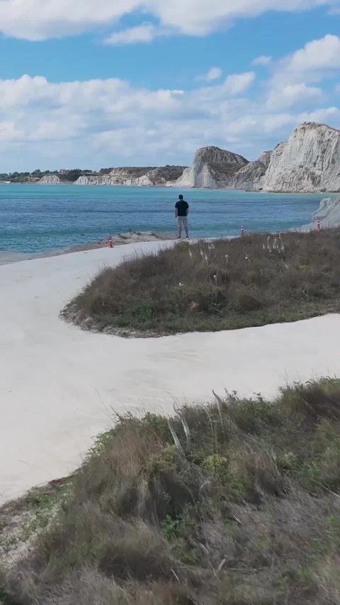 Tourist walking on white cliffs overlooking turquoise sea Stock Footage 290450434