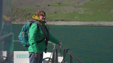 A tourist wearing a life jacket while waiting to go ashore at St Kilda, Scot Stock Footage 229336451