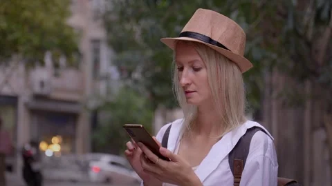 Tourist woman with backpack using smartphone on city street. 库存影片 252904061