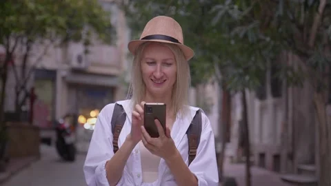 Tourist woman with backpack using smartphone on city street. Stock Footage 252925488