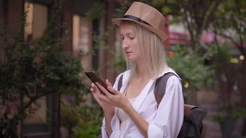 Tourist woman with backpack using smartphone on city street. 動画素材 252927607