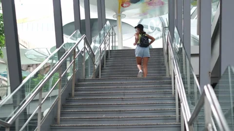 Tourist woman in white medical mask with backpack walk up on stairs  Stock Footage