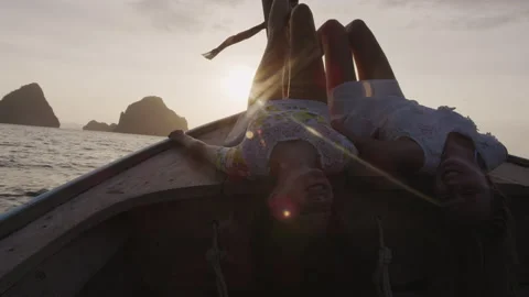Tourist women lying on deck of authentic long tail boat in Asia, legs in the air 库存影片 199475857
