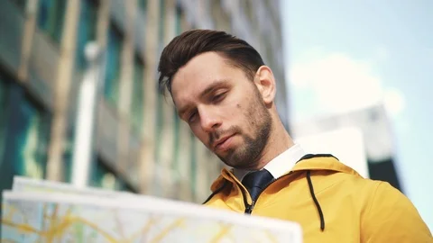 Tourist in yellow jacket looking at map Stock Footage 95591502