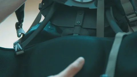 A tourist zips up backpack Stock Footage 90210530