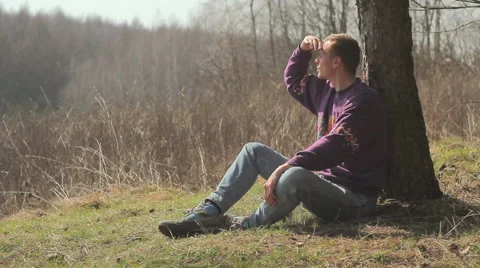 Tourist,guy tired,boy sitting under a tree,Guy examines all around Vídeos de archivo 48675688