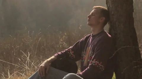 Tourist,guy tired,boy sitting under a tree,Guy examines all around Video stock 48725724