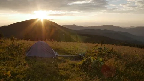 Touristic tent in mountains on sunset , wind shakes the grass Vídeos de archivo 77619731