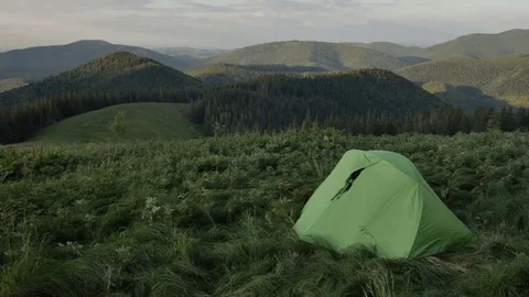 Touristic tent in mountains on sunset , wind shakes the grass 스톡 동영상 77620054