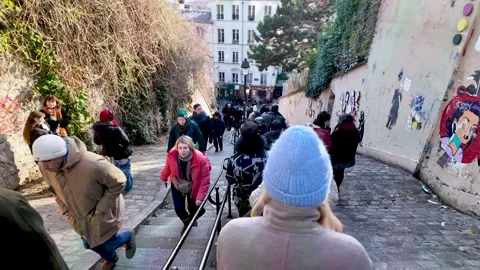 Tourists and locals walking down a busy Calvaire Street Stairs in Montmartre 動画素材 330915864