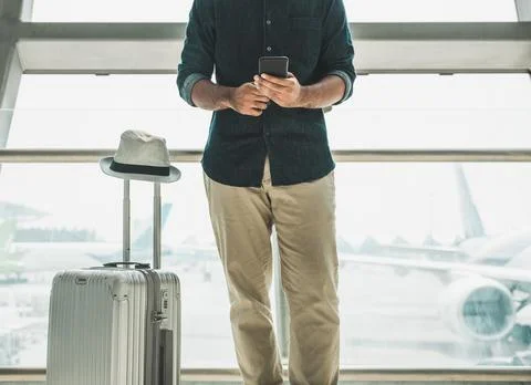Tourists are checking tour programs from their smartphones at the airport. Stock Photos