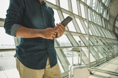 Tourists are checking tour programs from their smartphones at the airport. Stock Photos