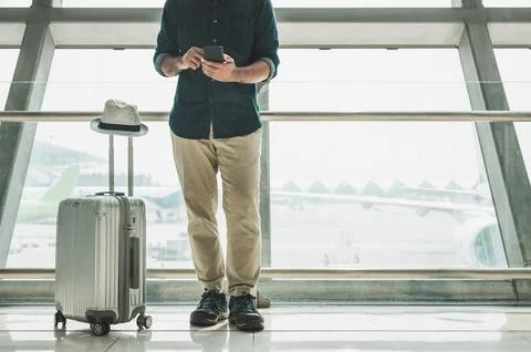 Tourists are checking tour programs from their smartphones at the airport. Stock Photos