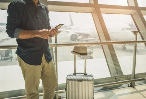 Tourists are checking tour programs from their smartphones at the airport. Stock Photos