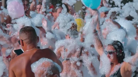 Tourists are having a great time dancing to cheerful music in the foam Stock Footage 323845962