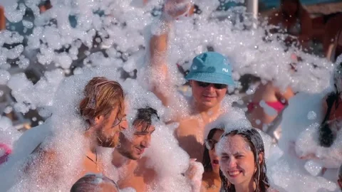 Tourists are having a great time dancing to cheerful music in the foam Stock Footage 323855055