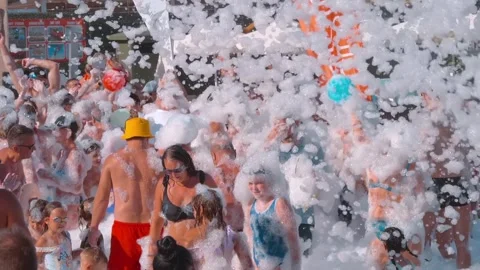 Tourists are having a great time dancing to cheerful music in the foam Stock Footage 323944391