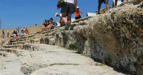 Tourists are sitting on the upper steps of the amphitheater feeling like a Stock Footage 118261722