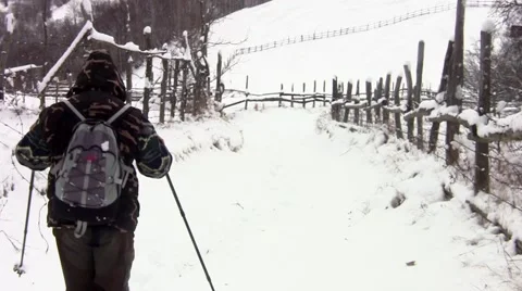Tourists with backpack behind down a road covered in snow, rushing to a cotta 57 Stock Footage 60401339