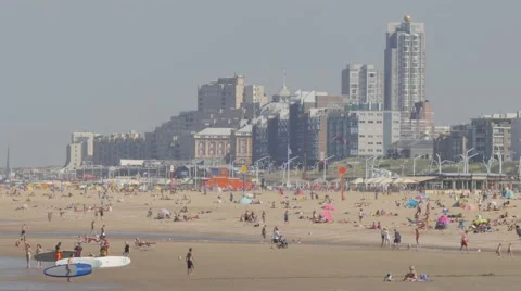 Tourists on beach with beachside hotels,Scheveningen,Netherlands Stock Footage