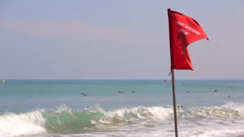 Tourists on a beach. Waving red flag. Kuta Beach resort in Bali. Rip current. 스톡 동영상 70107749