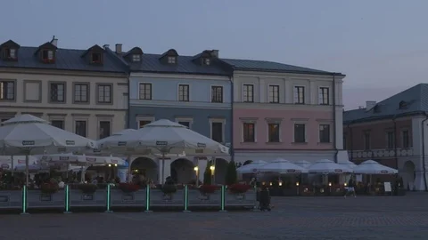 Tourists Bicycle through the Central Square of Zamosc, Poland Stock Footage 73483311