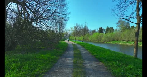 Tourists on bicycles. A walk by the river. Spring, sunny weather Stock Footage 322683992