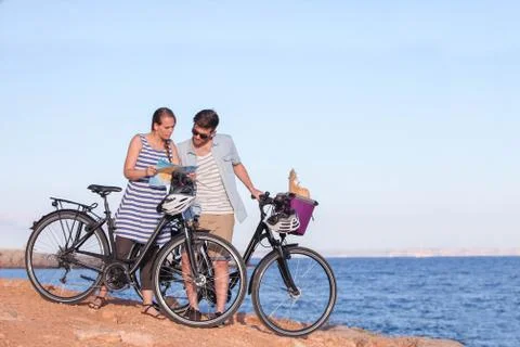 Tourists with bikes looking at map Stock Photos
