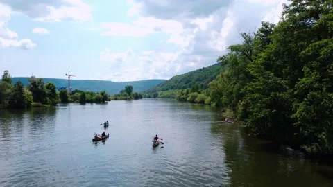 Tourists on boats with oars float along the river near the forest Stock Footage 155412683