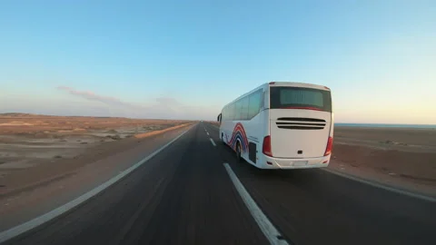 Tourists bus speeding on the empty desert road near Hurghada, Egypt at dusk Video stock 202319112