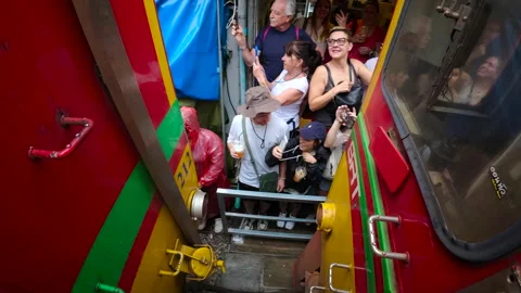 Tourists capturing the passing train at the Maeklong Railway Market Stock-Footage 310097193