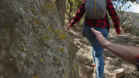 Tourists climb uphill along difficult rocky path Stock Footage 221655536