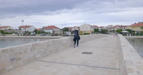 Tourists cross the bridge. They keep their distance because of the corona virus. Video stock 137875598